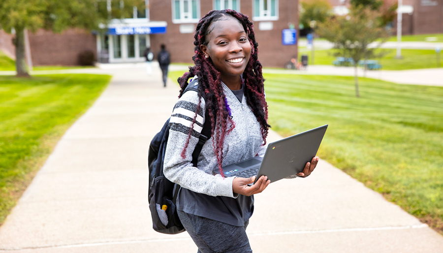 black woman holding laptop and smiling on SUNY Ulster campus