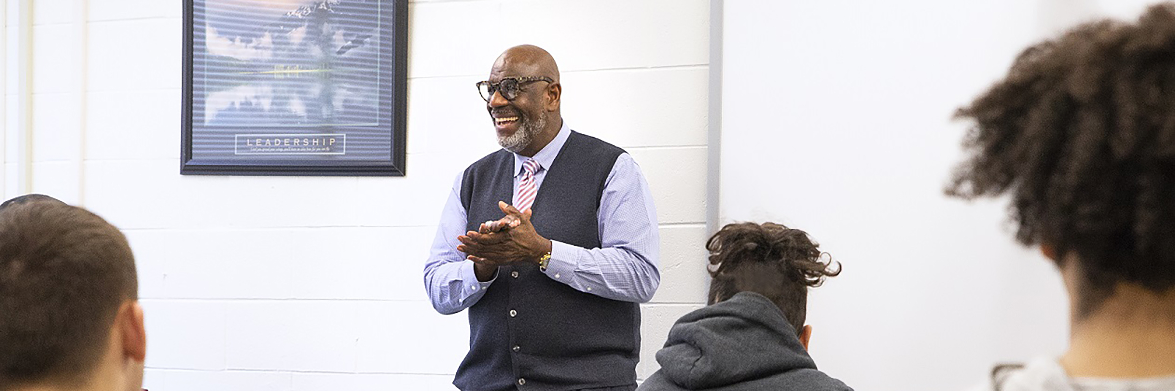 black man teacher smiling in front of classroom