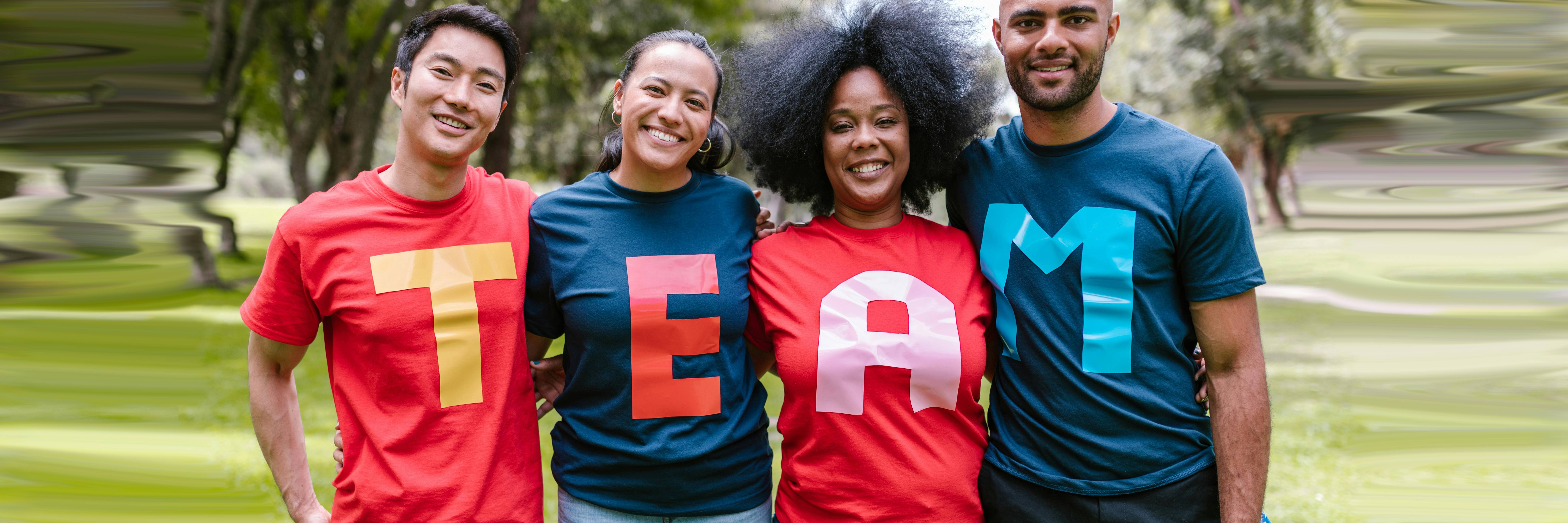 group of diverse adults wearing bright shirts that spell out TEAM