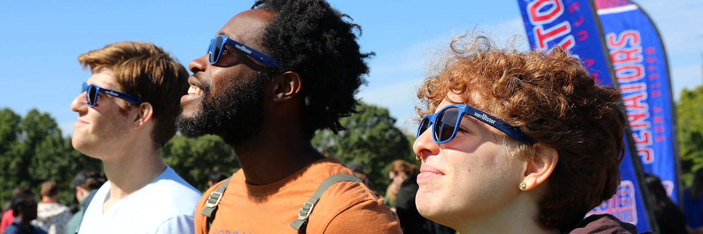 three diverse students in matching SUNY Ulster sunglasses